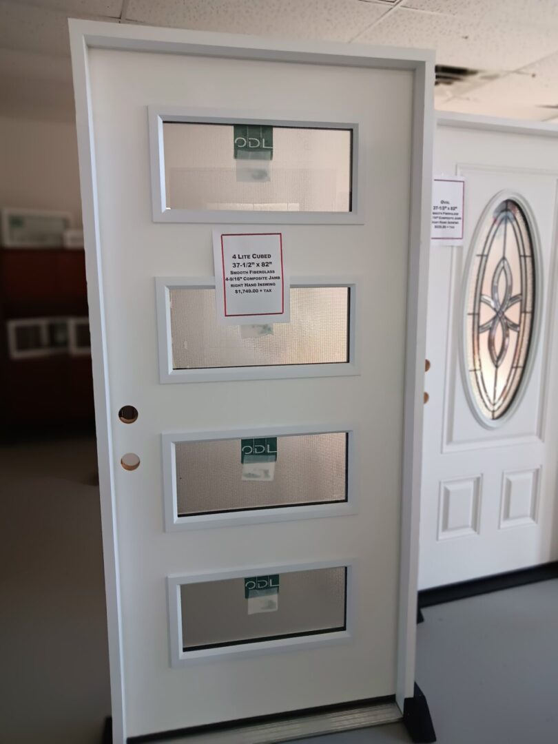 exterior home door with four glass inserts displayed in warehouse